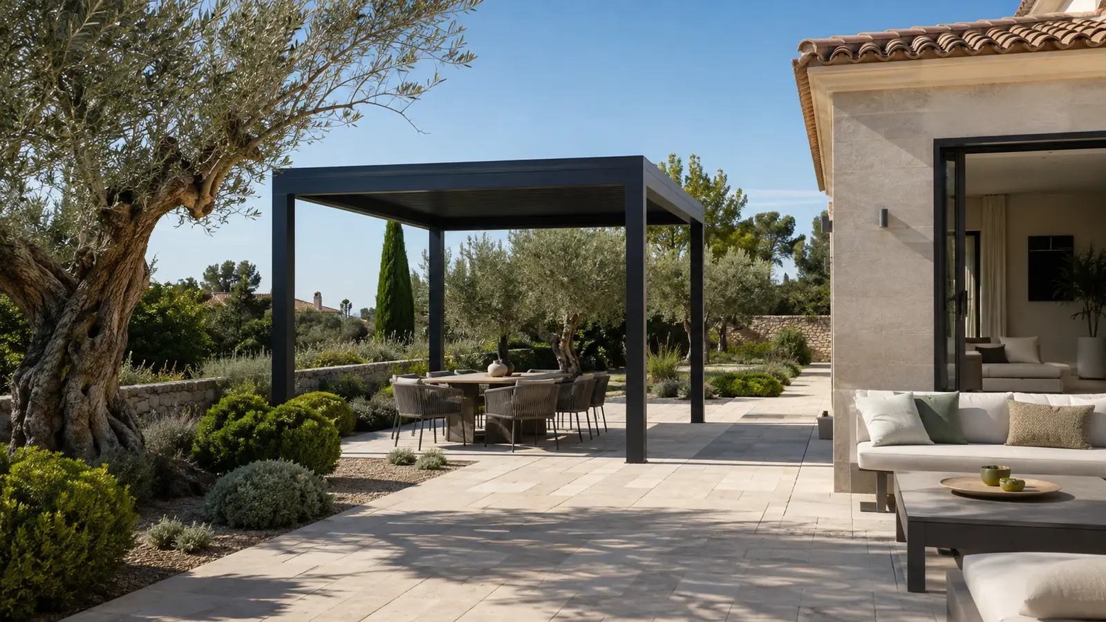 Une pergola anthracite autoportée abrite un salon extérieur dans un jardin méditerranéen