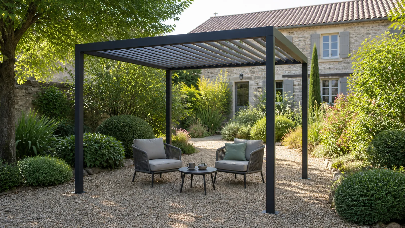 Pergola autoportée anthracite à quatre poteaux avec deux fauteuils dans un jardin français arboré