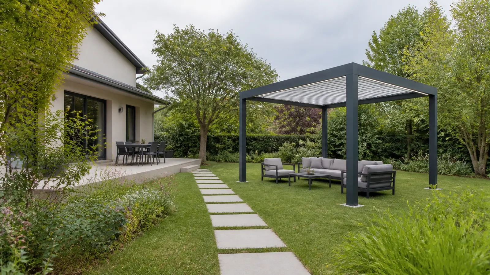 Pergola carrée autoportée aménagée en salon et reliée à la maison par un chemin dallé
