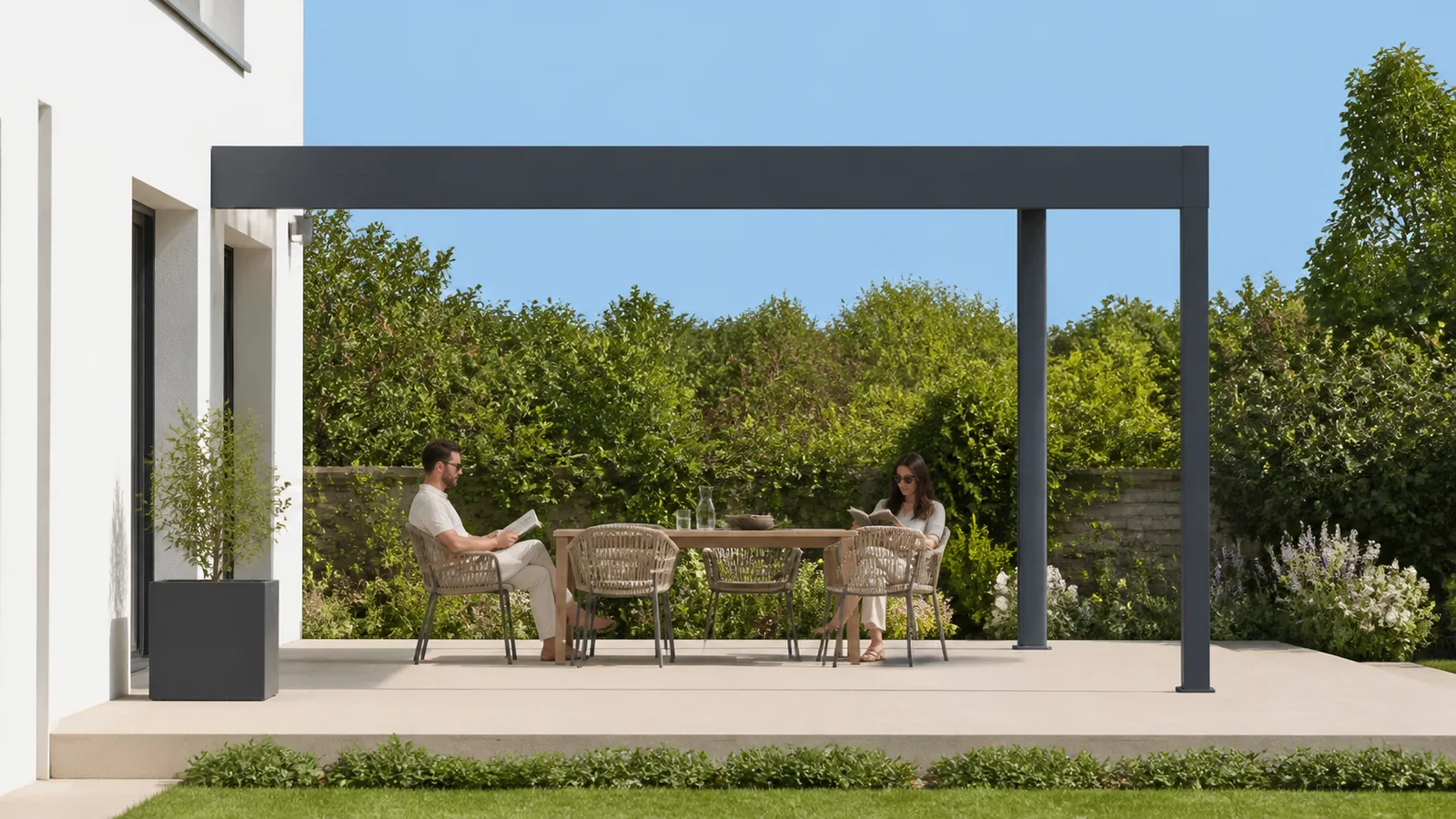 Deux personnes lisent au soleil sur une terrasse ouverte encadrée par une pergola anthracite