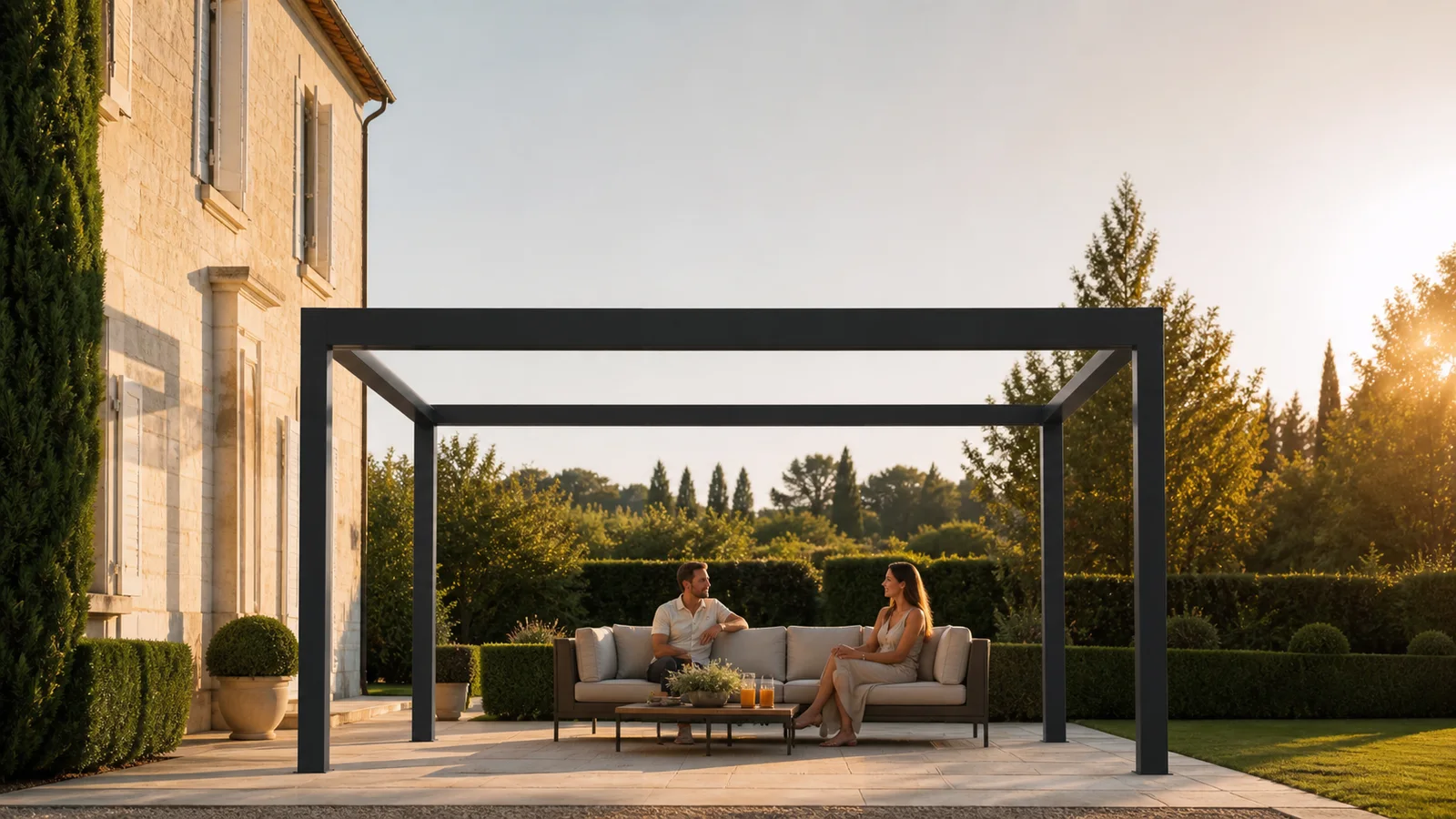 Couple assis dans un salon extérieur alors que le soleil bas éclaire le côté de la terrasse