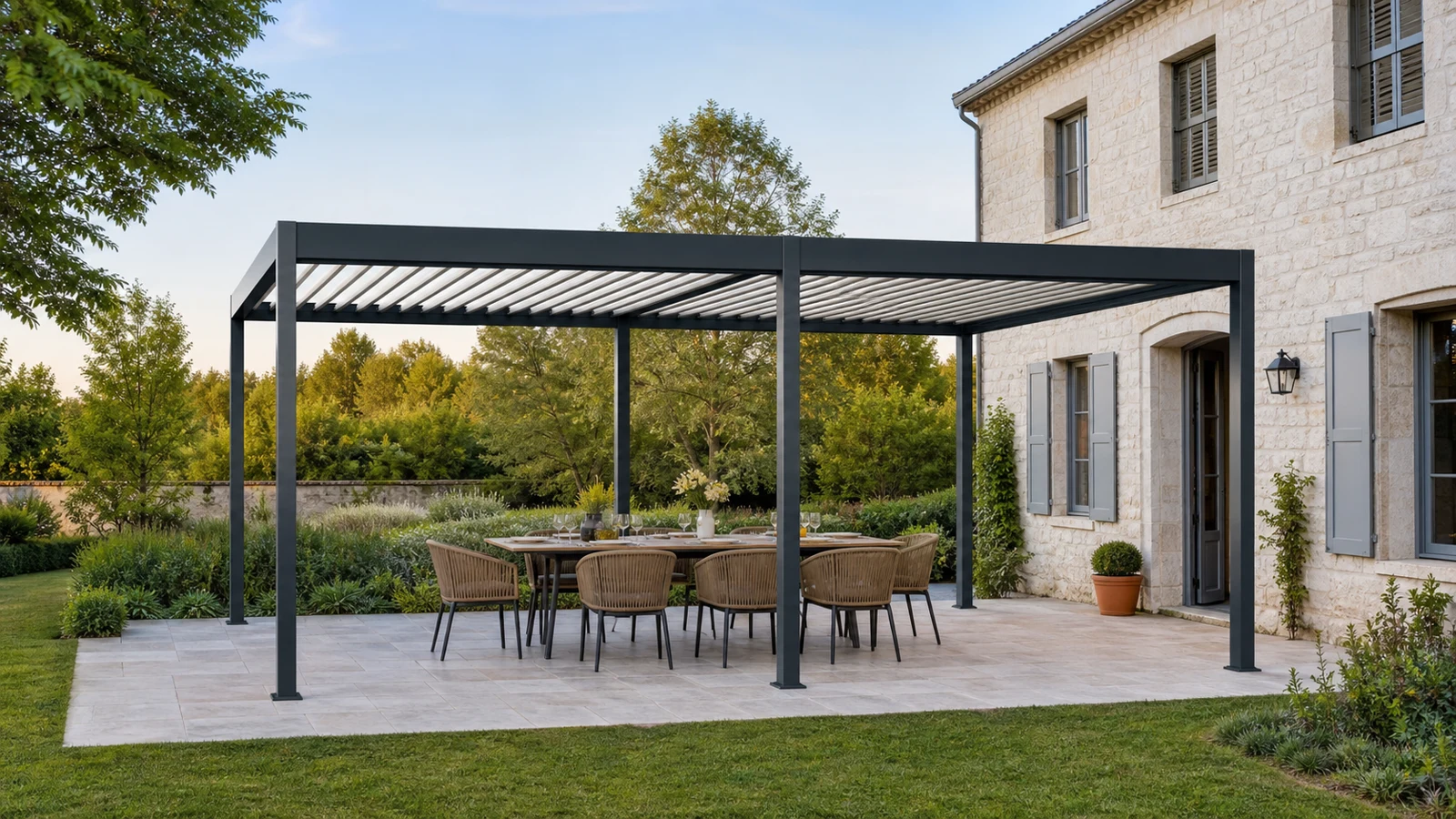 Une grande pergola autoportée à deux travées abrite une table familiale dans un jardin